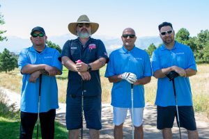 4 people posing for a picture on a golf course