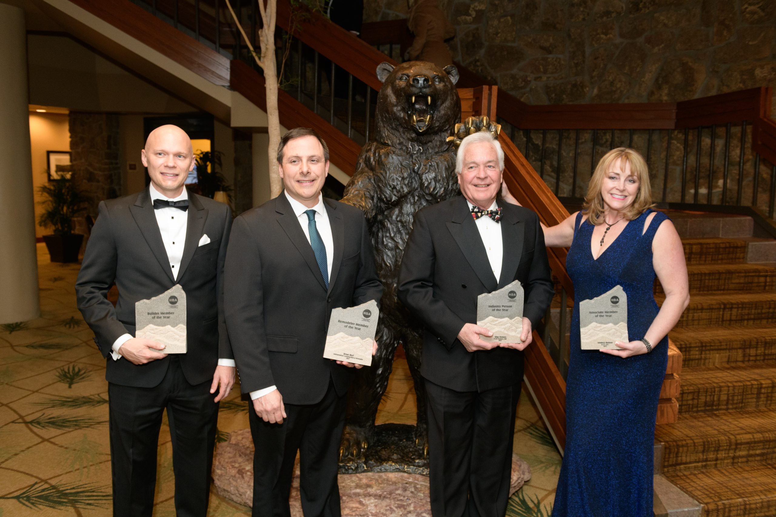 four people posing for a photo with their awards