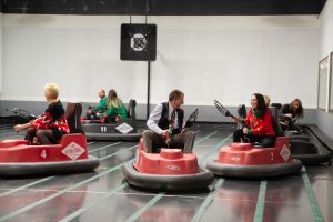 7 people playing whirly ball on bumper cars